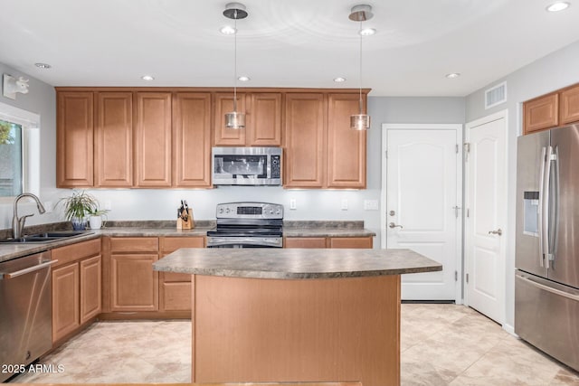 kitchen with a kitchen island, appliances with stainless steel finishes, sink, and hanging light fixtures