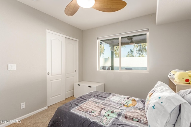 carpeted bedroom with ceiling fan and a closet