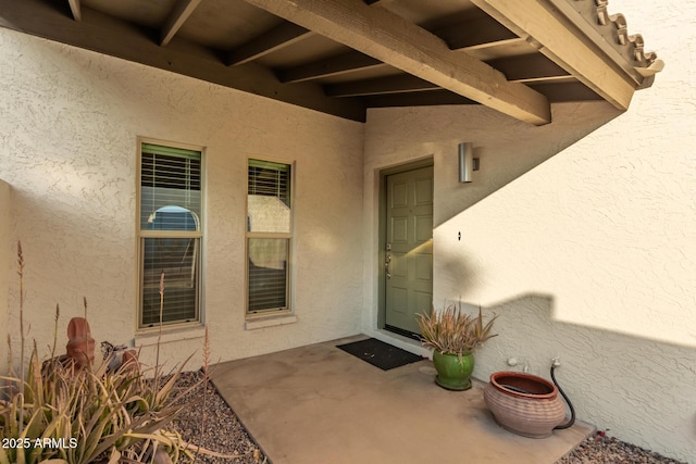 view of exterior entry with a patio area