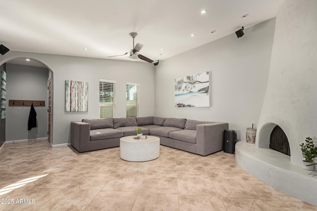 living room with a premium fireplace and ceiling fan