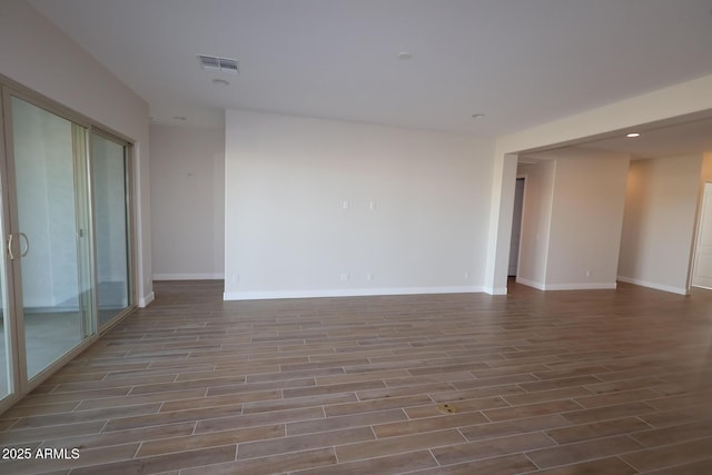 unfurnished room with wood finished floors, baseboards, and recessed lighting