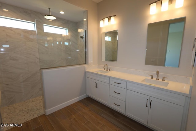 full bath featuring a walk in shower, double vanity, wood finished floors, and recessed lighting
