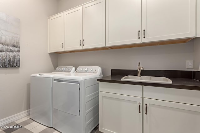 laundry room featuring washing machine and clothes dryer, sink, and cabinets