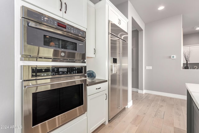 kitchen featuring white cabinetry, light hardwood / wood-style flooring, and appliances with stainless steel finishes