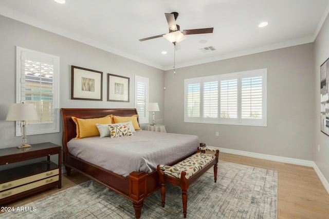 bedroom featuring ceiling fan, light hardwood / wood-style floors, and crown molding