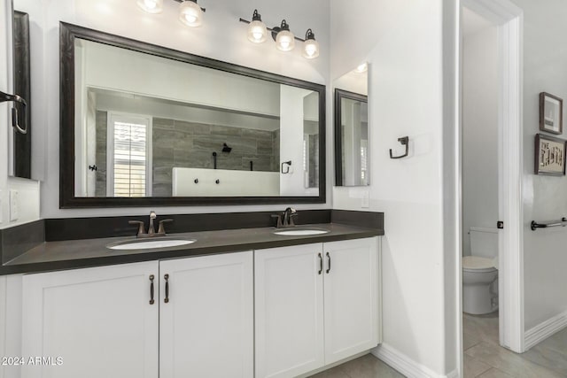 bathroom with a tile shower, tile patterned flooring, vanity, and toilet