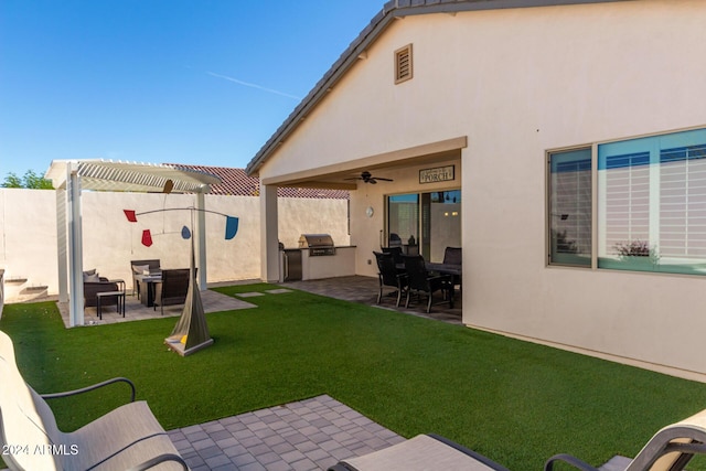 view of yard with an outdoor kitchen, ceiling fan, a patio area, and a pergola