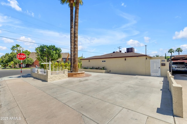 view of property exterior with a gate and stucco siding