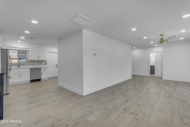 unfurnished living room with recessed lighting, baseboards, a sink, light wood finished floors, and a ceiling fan