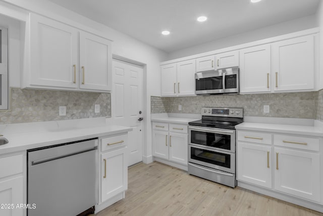 kitchen featuring stainless steel appliances, white cabinets, and recessed lighting