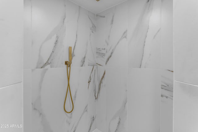 bathroom view of a marble finish shower