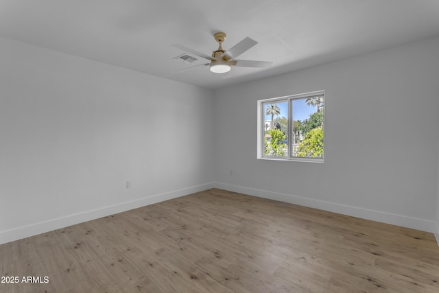 empty room featuring baseboards, a ceiling fan, and wood finished floors