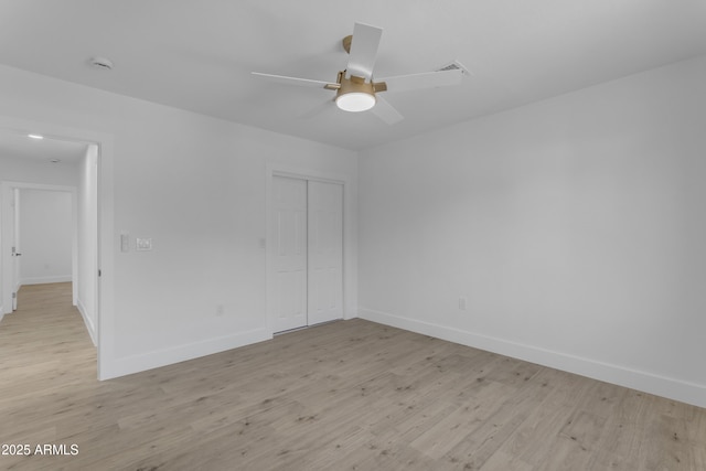 unfurnished room featuring baseboards, light wood-style floors, and ceiling fan