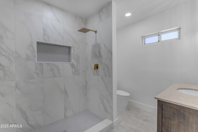 bathroom featuring toilet, a marble finish shower, vanity, and baseboards