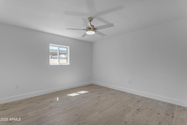 unfurnished room with baseboards, light wood-style flooring, and ceiling fan