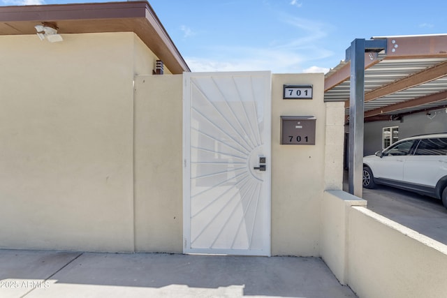 property entrance featuring a gate and stucco siding