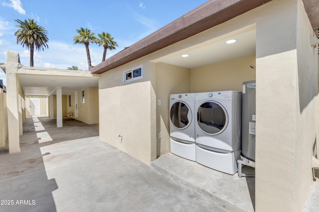 laundry area with washing machine and clothes dryer and water heater
