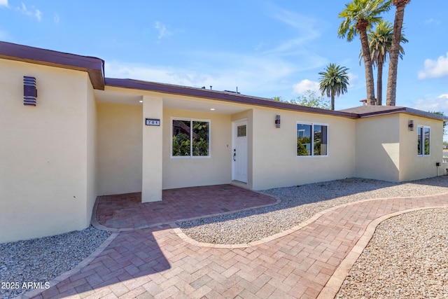 entrance to property featuring stucco siding and a patio