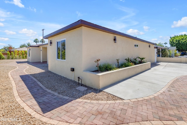 view of home's exterior with stucco siding and a patio area