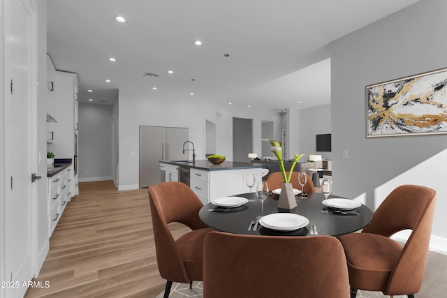 dining area featuring sink and light wood-type flooring