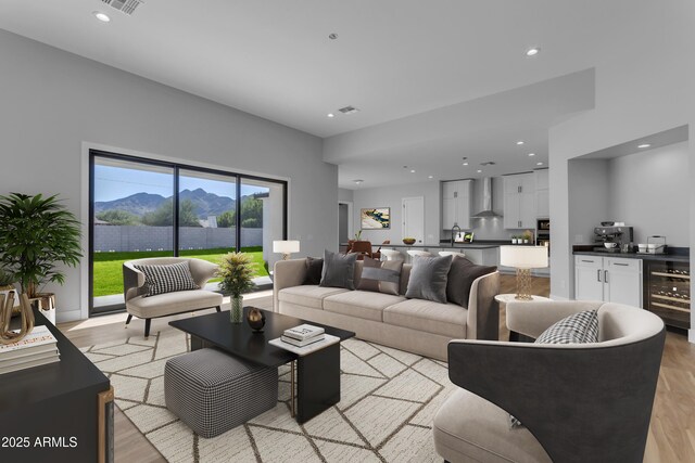 living room featuring wine cooler, a mountain view, and light hardwood / wood-style flooring