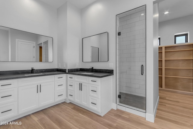 bathroom with an enclosed shower, vanity, and wood-type flooring