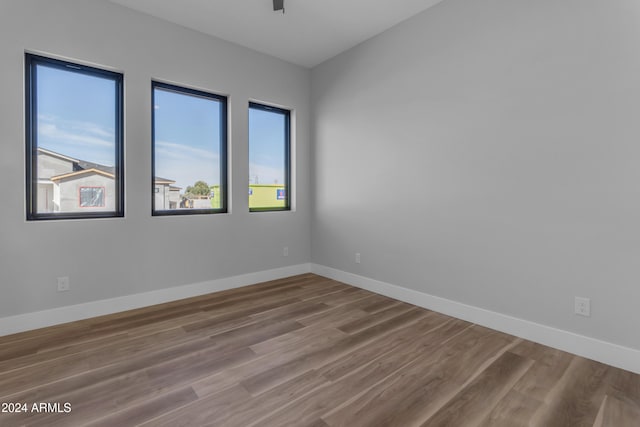 empty room with hardwood / wood-style floors and ceiling fan