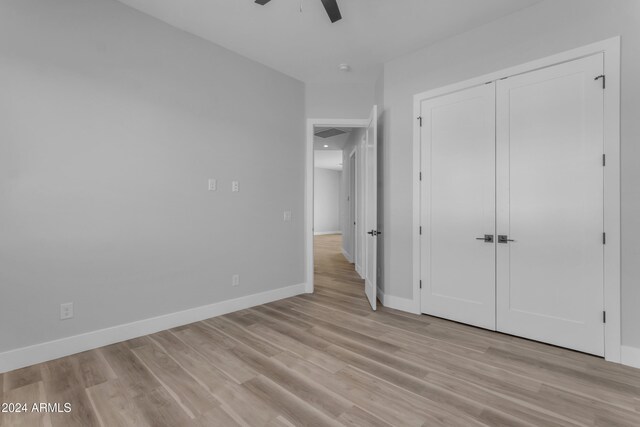 unfurnished bedroom with a closet, ceiling fan, and light hardwood / wood-style flooring