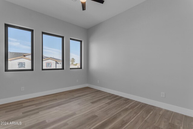 empty room with ceiling fan and light wood-type flooring