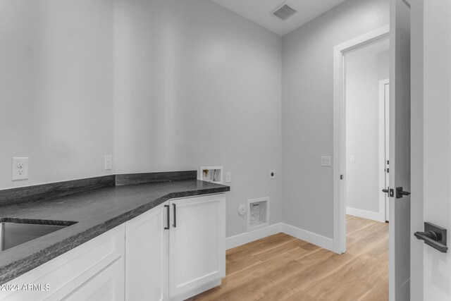 laundry room with sink, cabinets, light hardwood / wood-style flooring, hookup for a washing machine, and electric dryer hookup