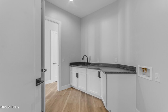 washroom featuring cabinets, washer hookup, light hardwood / wood-style floors, and sink