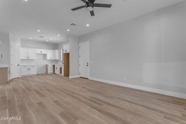 unfurnished living room featuring ceiling fan and light hardwood / wood-style flooring