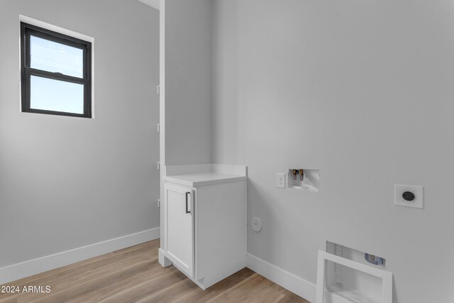 washroom with gas dryer hookup, washer hookup, hookup for an electric dryer, and light hardwood / wood-style floors