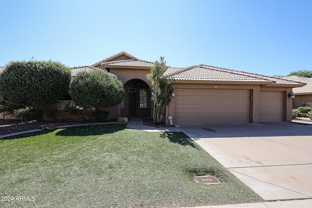 mediterranean / spanish-style home with a front yard and a garage