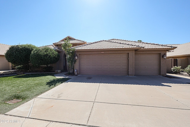 view of front of property with a garage and a front lawn