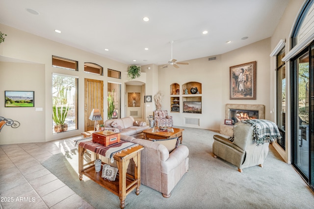 tiled living room featuring built in shelves and ceiling fan