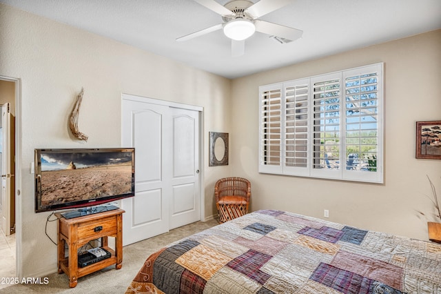 bedroom with ceiling fan, a closet, and light carpet