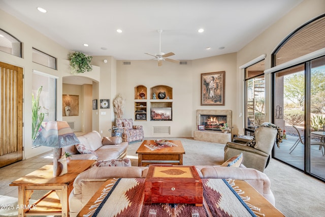 tiled living room with built in shelves and ceiling fan