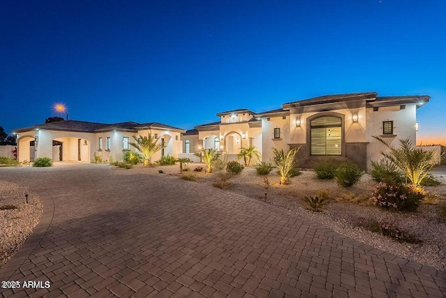 mediterranean / spanish-style home featuring decorative driveway and stucco siding