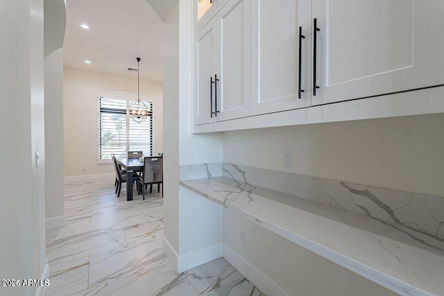 kitchen featuring glass insert cabinets, marble finish floor, light stone counters, and white cabinets