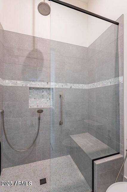 bathroom with toilet and tiled shower