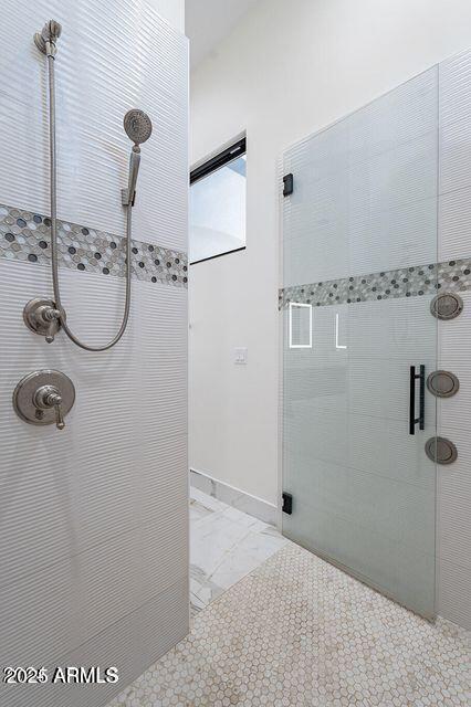 bathroom with a stall shower, marble finish floor, and baseboards