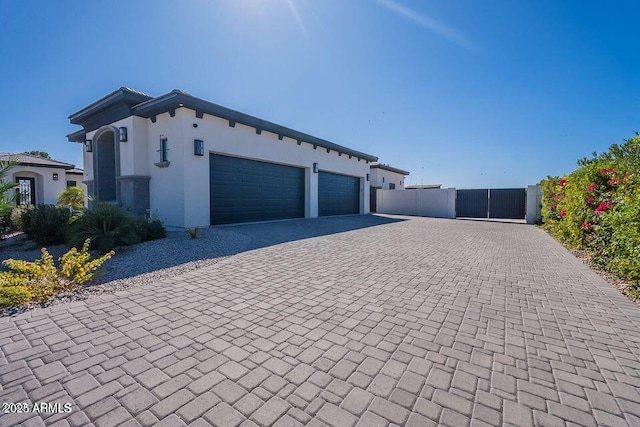 exterior space with decorative driveway, an attached garage, and stucco siding