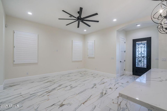 foyer with arched walkways, marble finish floor, recessed lighting, ceiling fan, and baseboards