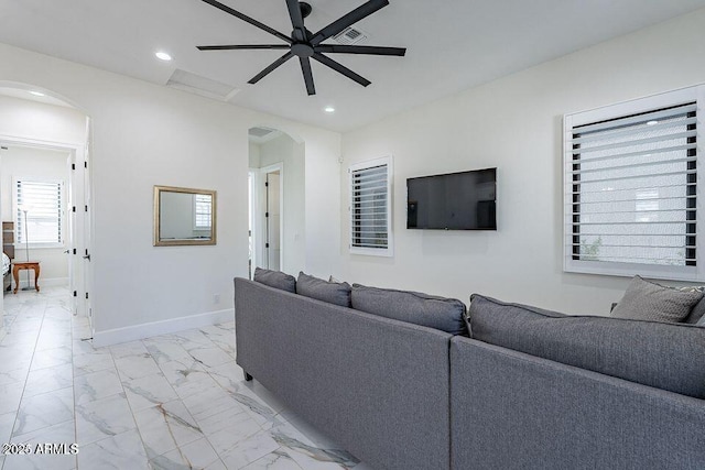 living room featuring marble finish floor, baseboards, arched walkways, and recessed lighting