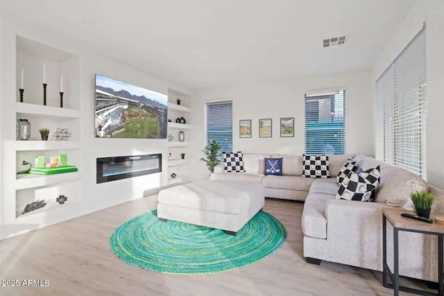 29228 N 48th St, Cave Creek, AZ 85331 - living area featuring visible vents, built in features, wood finished floors, and a glass covered fireplace