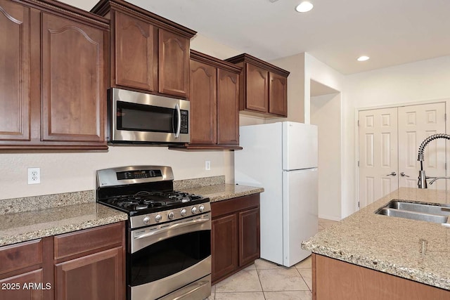 7712 S 37th Way, Phoenix, AZ 85042 - kitchen with stainless steel appliances, a sink, light stone counters, light tile patterned floors, and recessed lighting
