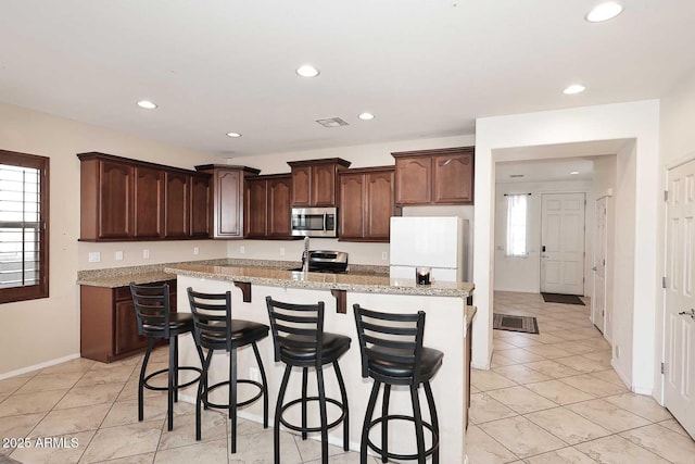 7712 S 37th Way, Phoenix, AZ 85042 - kitchen featuring stainless steel appliances, healthy amount of natural light, a center island with sink, recessed lighting, and a breakfast bar