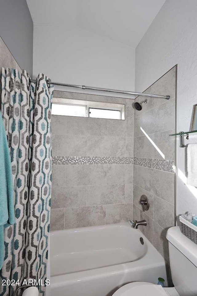 bathroom with toilet and shower / tub combo with curtain