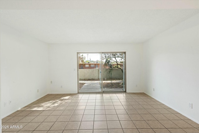 unfurnished room featuring a textured ceiling and light tile patterned floors